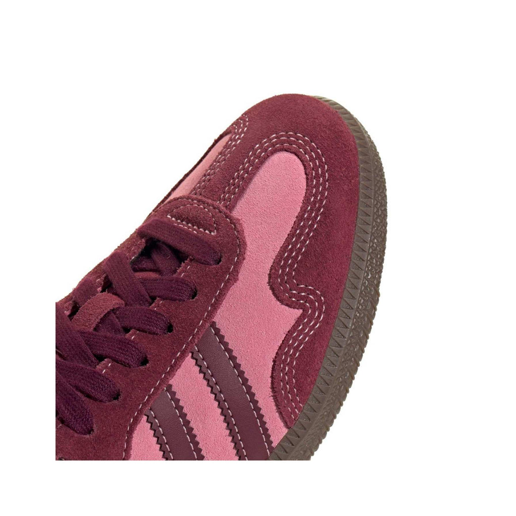 Close-up of a maroon and pink sneaker on a white background