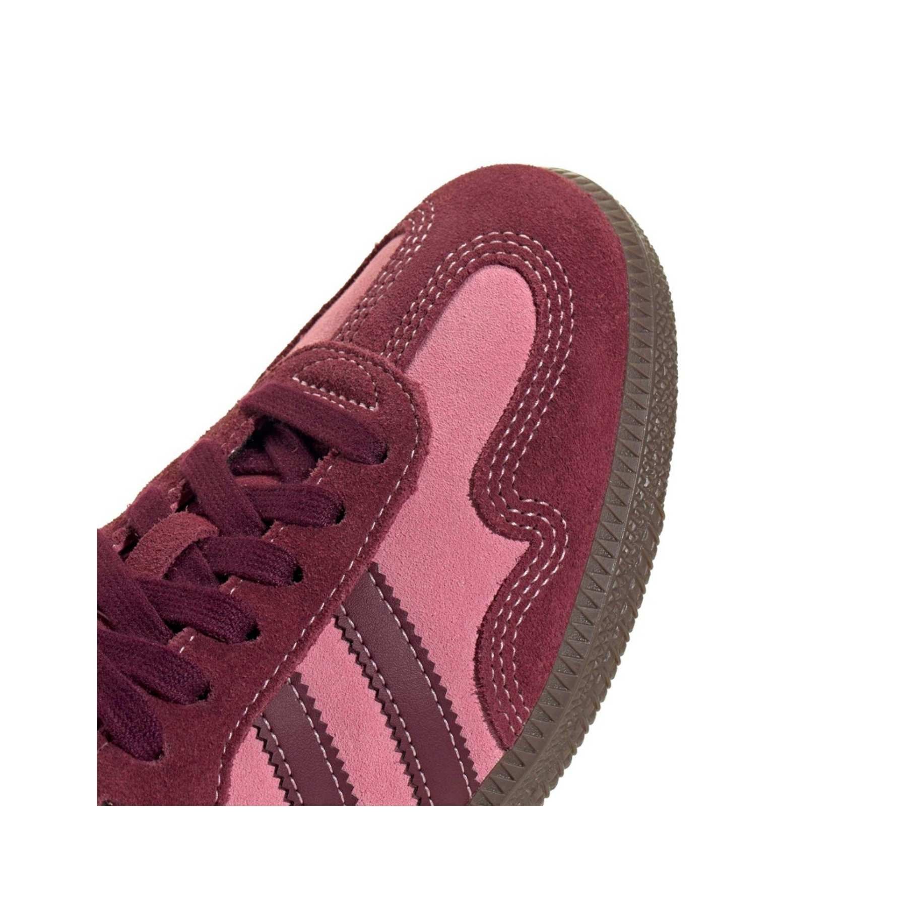 Close-up of a maroon and pink sneaker on a white background