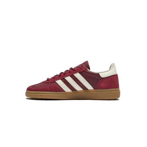 Maroon Adidas sneaker with white stripes on a white background