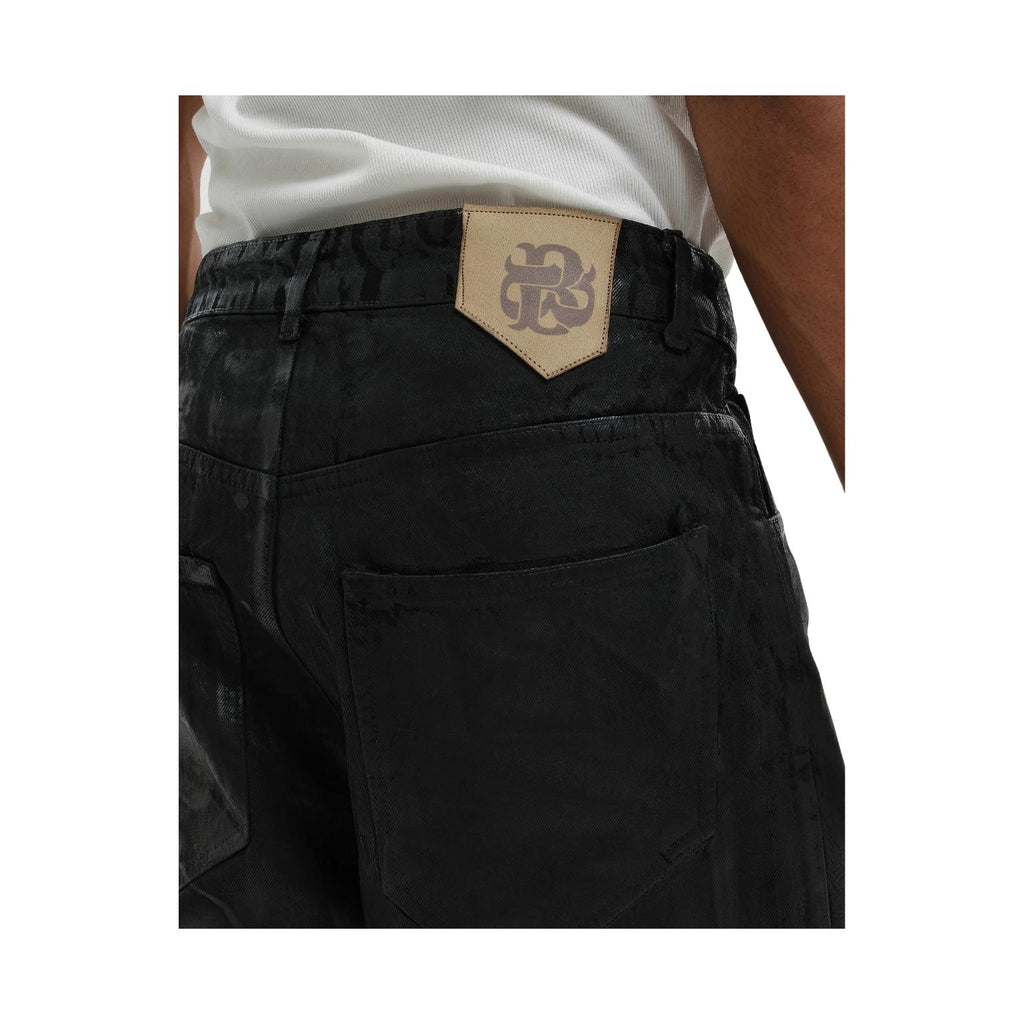 Close-up of a person wearing black denim cargo shorts with a beige leather patch featuring a stylized 'RS' logo at the back waistband.