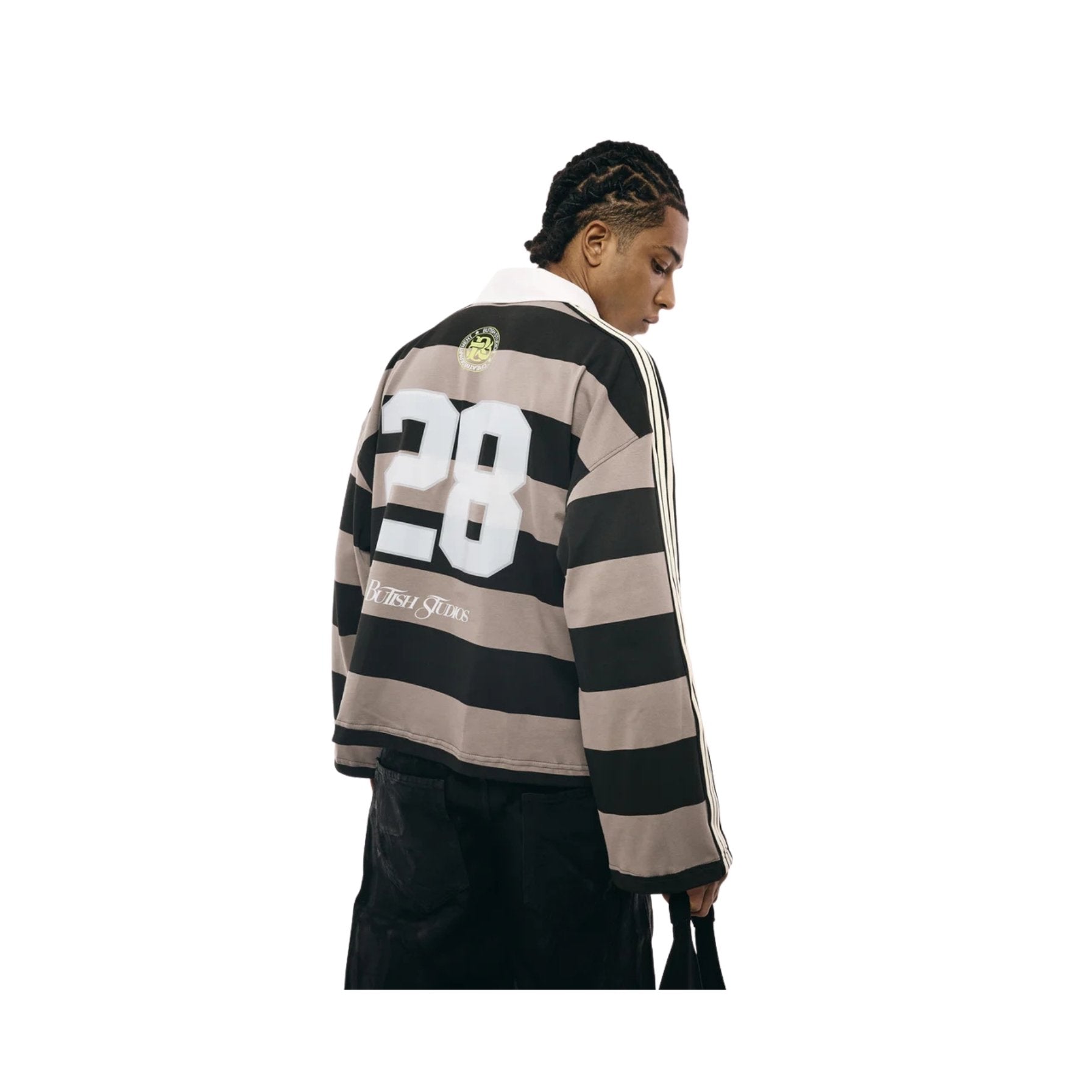 Person wearing a black and beige striped sweater with number 28 on a white background