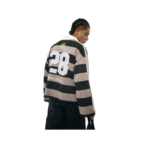 Person wearing a black and beige striped sweater with number 28 on a white background