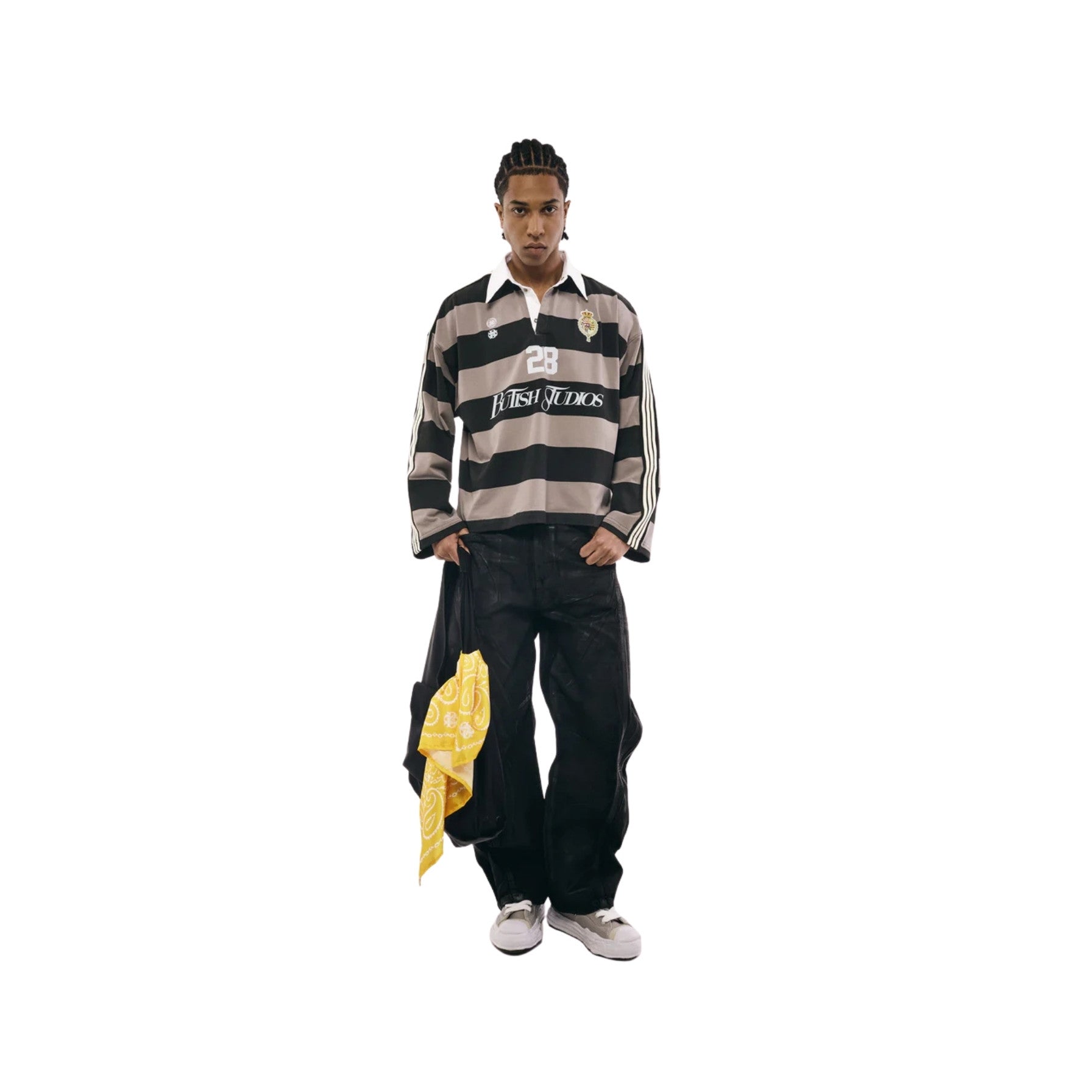 Person wearing a striped shirt and black pants with a yellow jacket on a white background