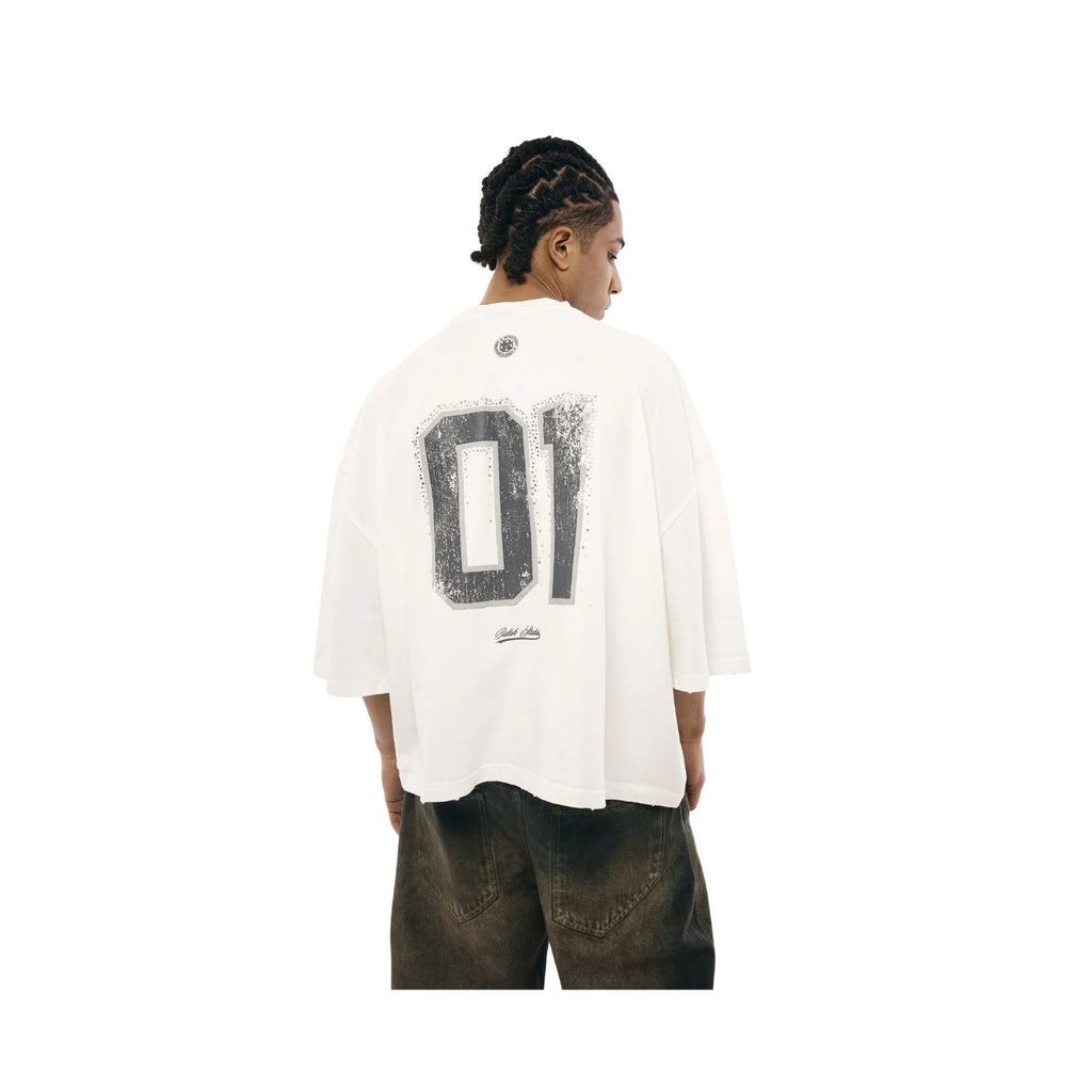 Person wearing a white shirt with a large black number '01' on the back, standing against a white background.