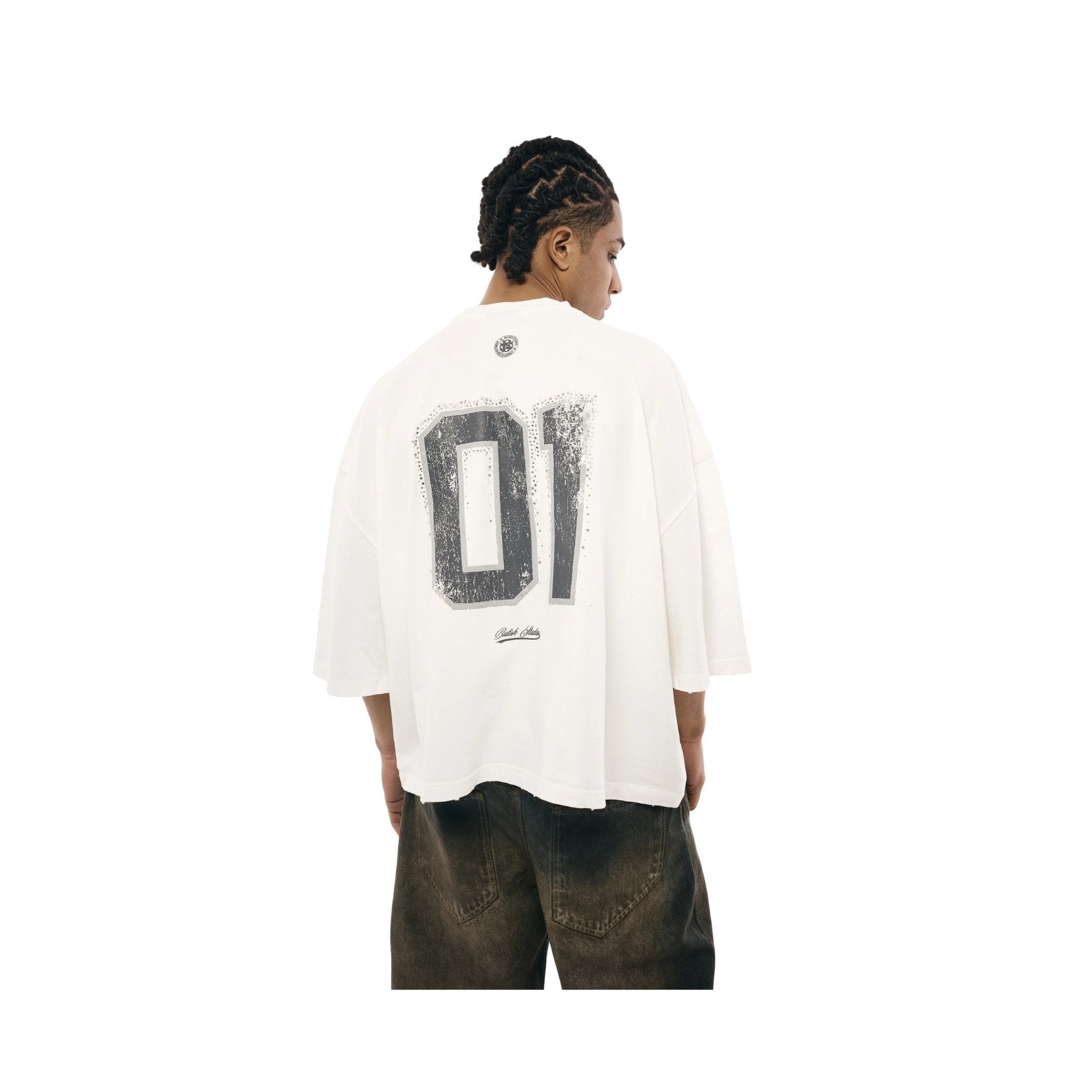 Person wearing a white shirt with a large black number '01' on the back, standing against a white background.