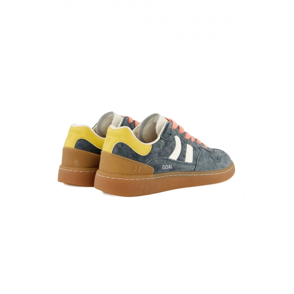 A pair of low-top sneakers shown from the side and back on a plain white background. The shoes feature a slate blue-gray suede upper with a bright yellow heel tab, a white side stripe, a brown gum sole, and coral-pink laces.