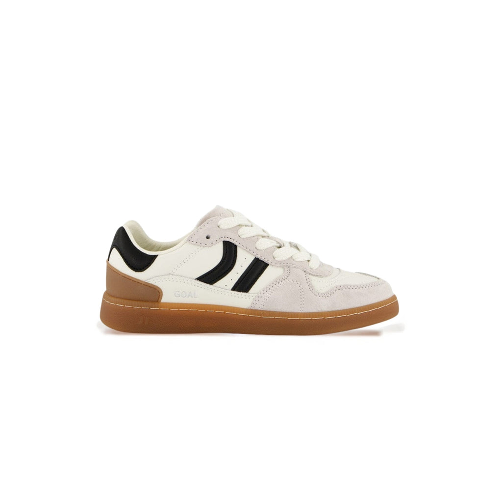 A low-top sneaker in off-white suede and leather with black side stripes, a tan heel counter, and a brown gum sole, shown in profile against a white background.