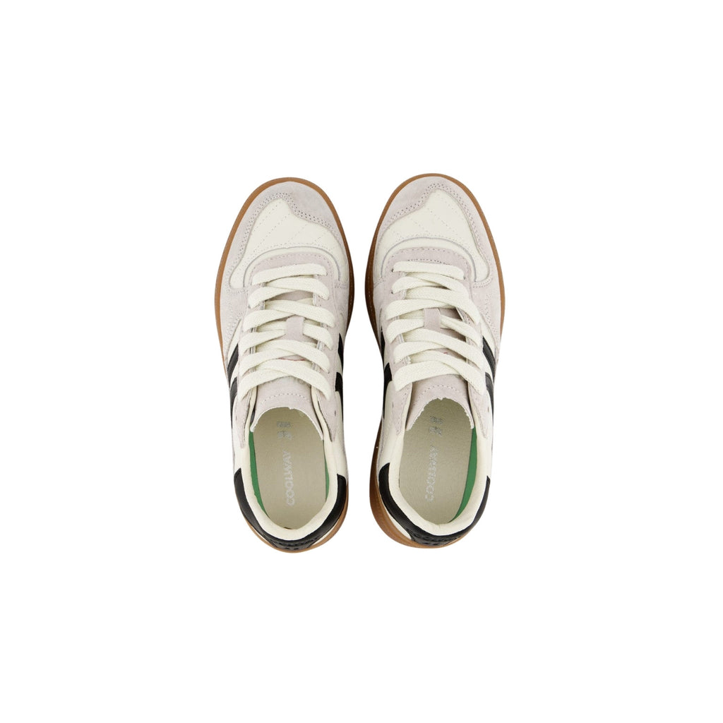 A pair of vintage-style low-top sneakers shown from a top-down view. The shoes feature off-white suede panels, cream laces, a brown gum sole, and black side stripes, with a light green interior lining visible.