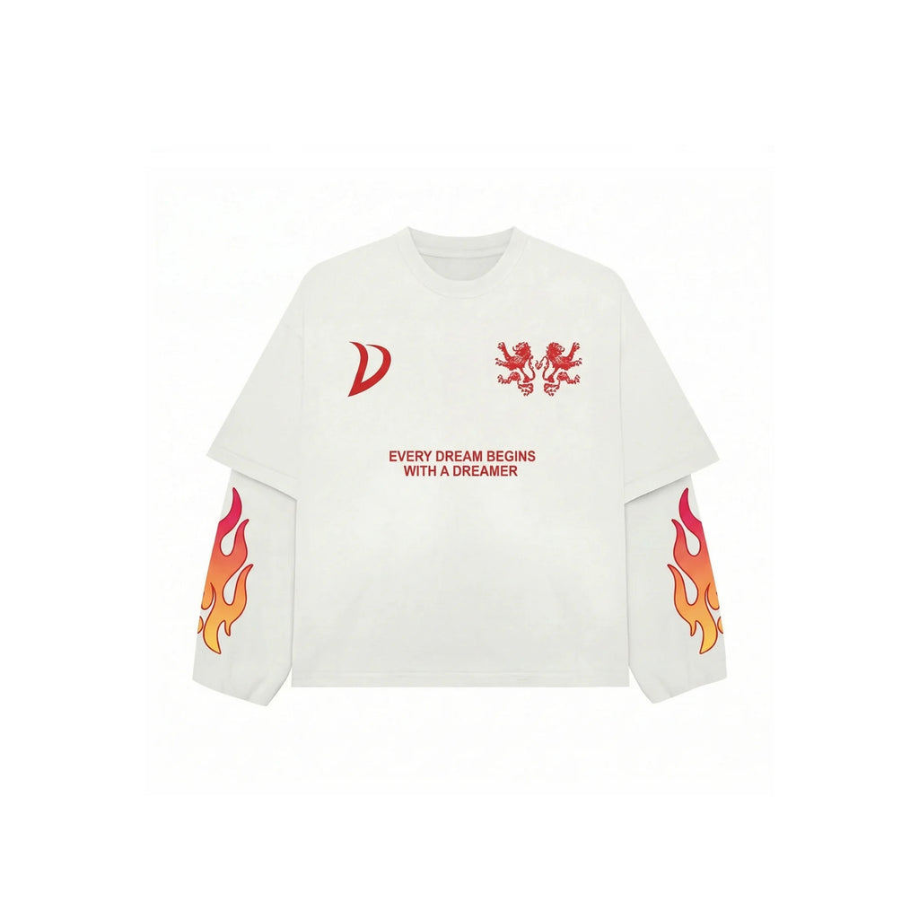 A white long-sleeve t-shirt with red graphic prints, including a stylized 'D' logo on the right chest, a double-headed eagle emblem on the left chest, the text 'EVERY DREAM BEGINS WITH A DREAMER' in the center, and flame graphics on both sleeves.