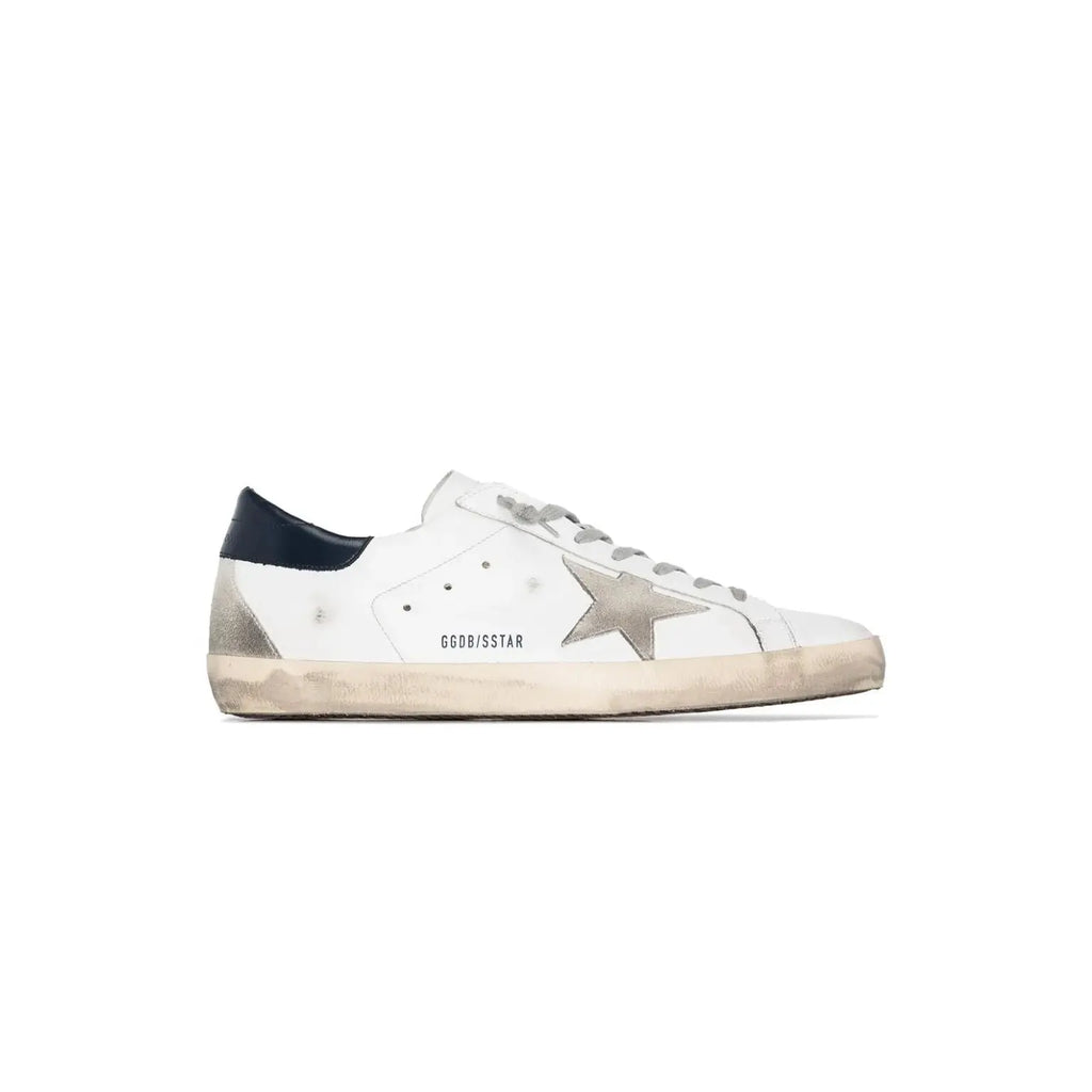 A single Golden Goose Super-Star sneaker in white leather with a distressed finish, featuring a metallic silver star on the side, a navy blue heel tab, and a beige gum sole.