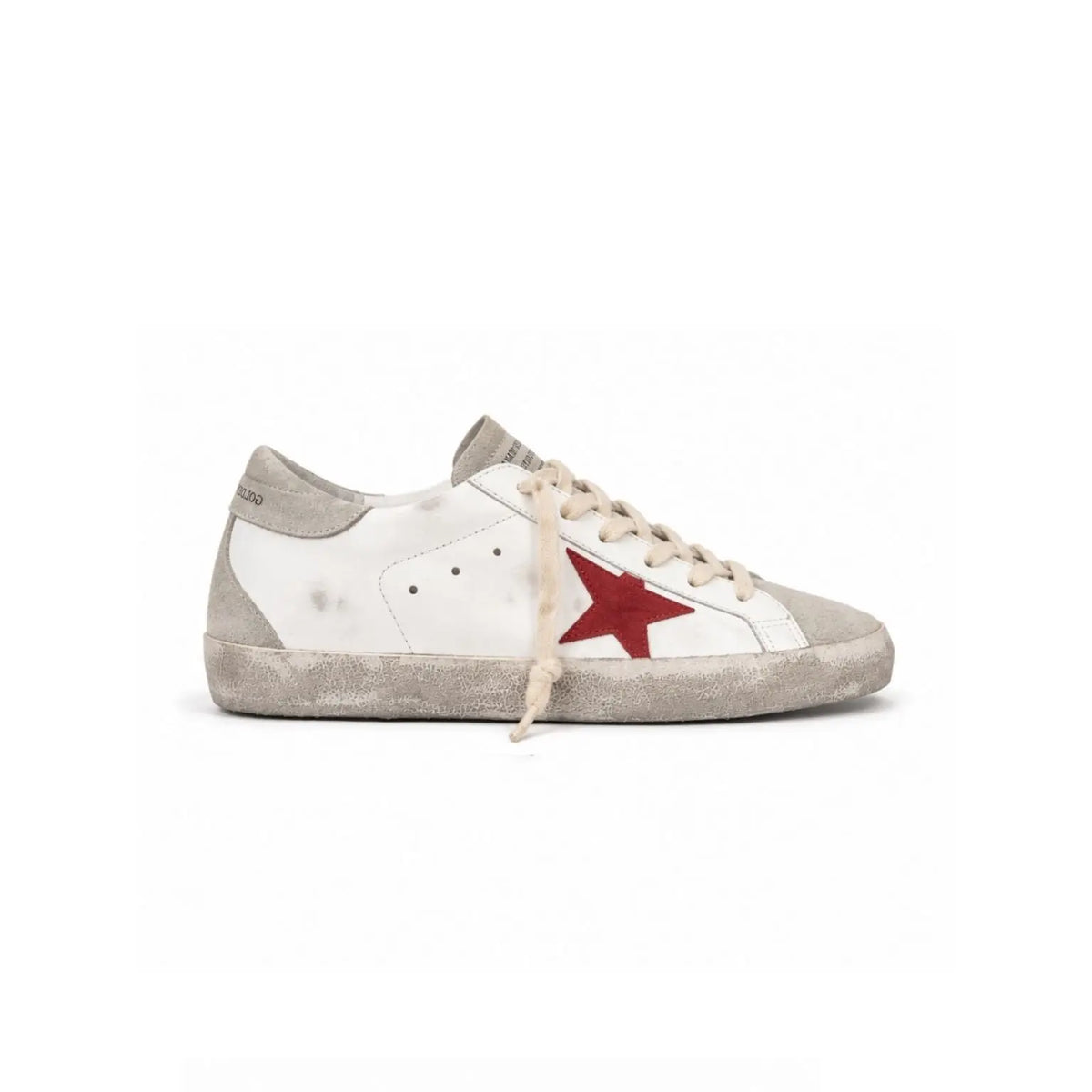 A single Golden Goose sneaker in distressed white leather with a red star logo on the side, beige laces, and a light gray suede toe and heel, shown against a plain white background.