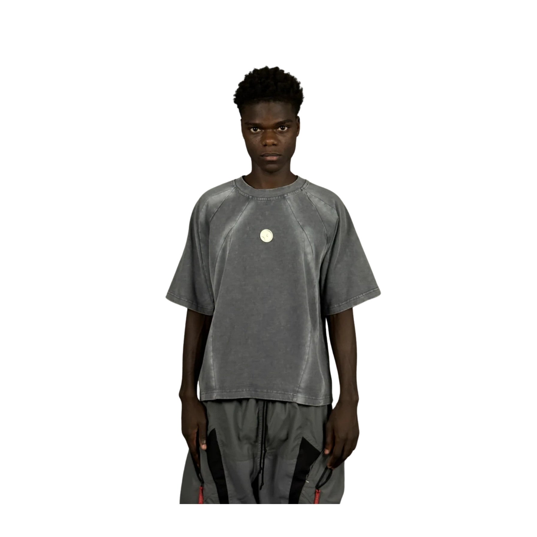 Person wearing a gray t-shirt with a logo on a white background