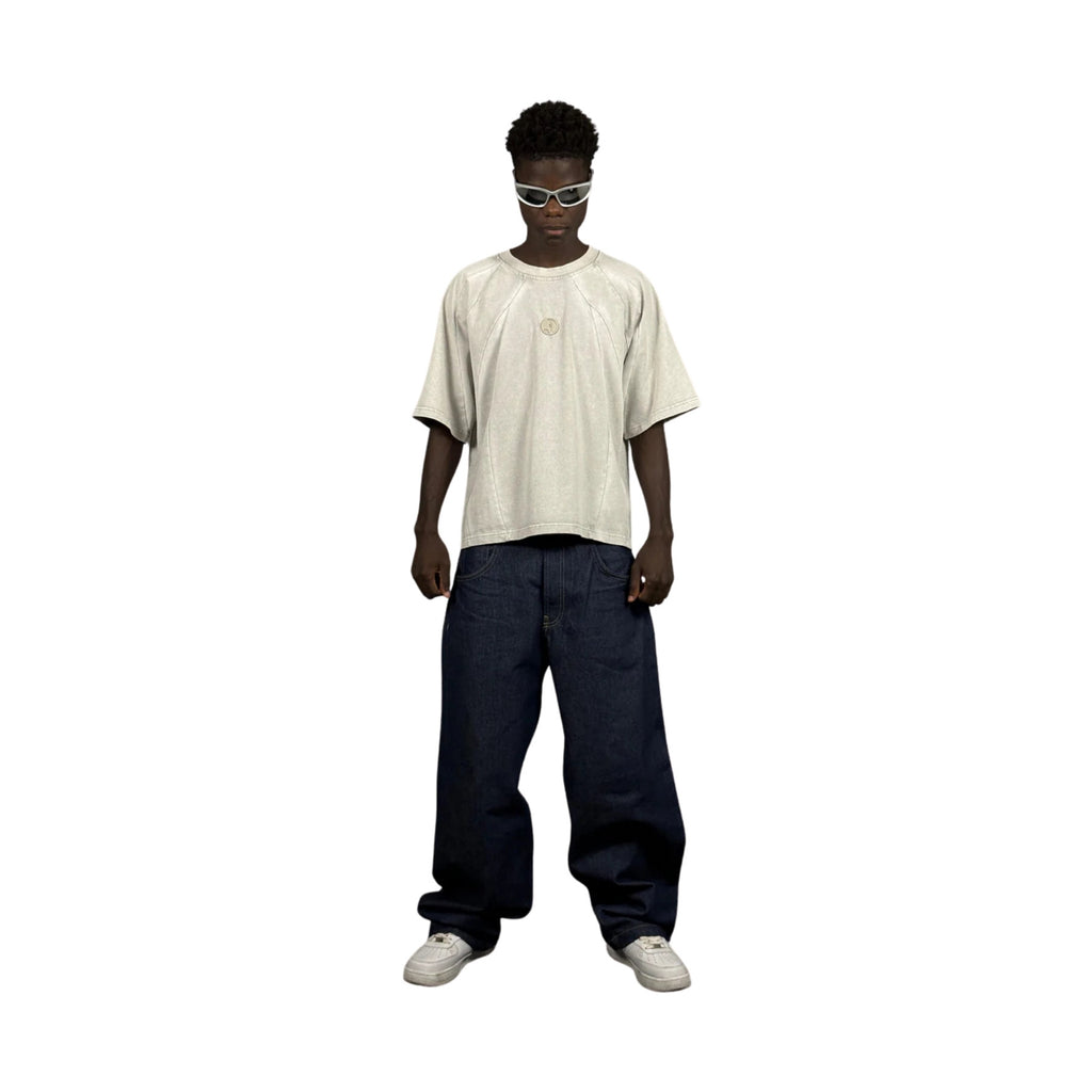Person wearing a white t-shirt and dark jeans on a white background
