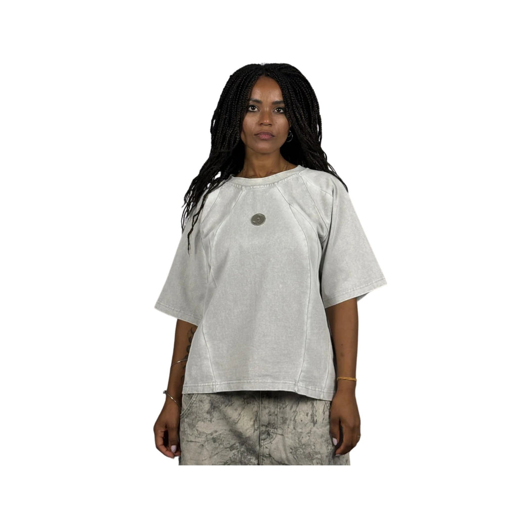 Woman wearing a light gray t-shirt with a circular design on a white background