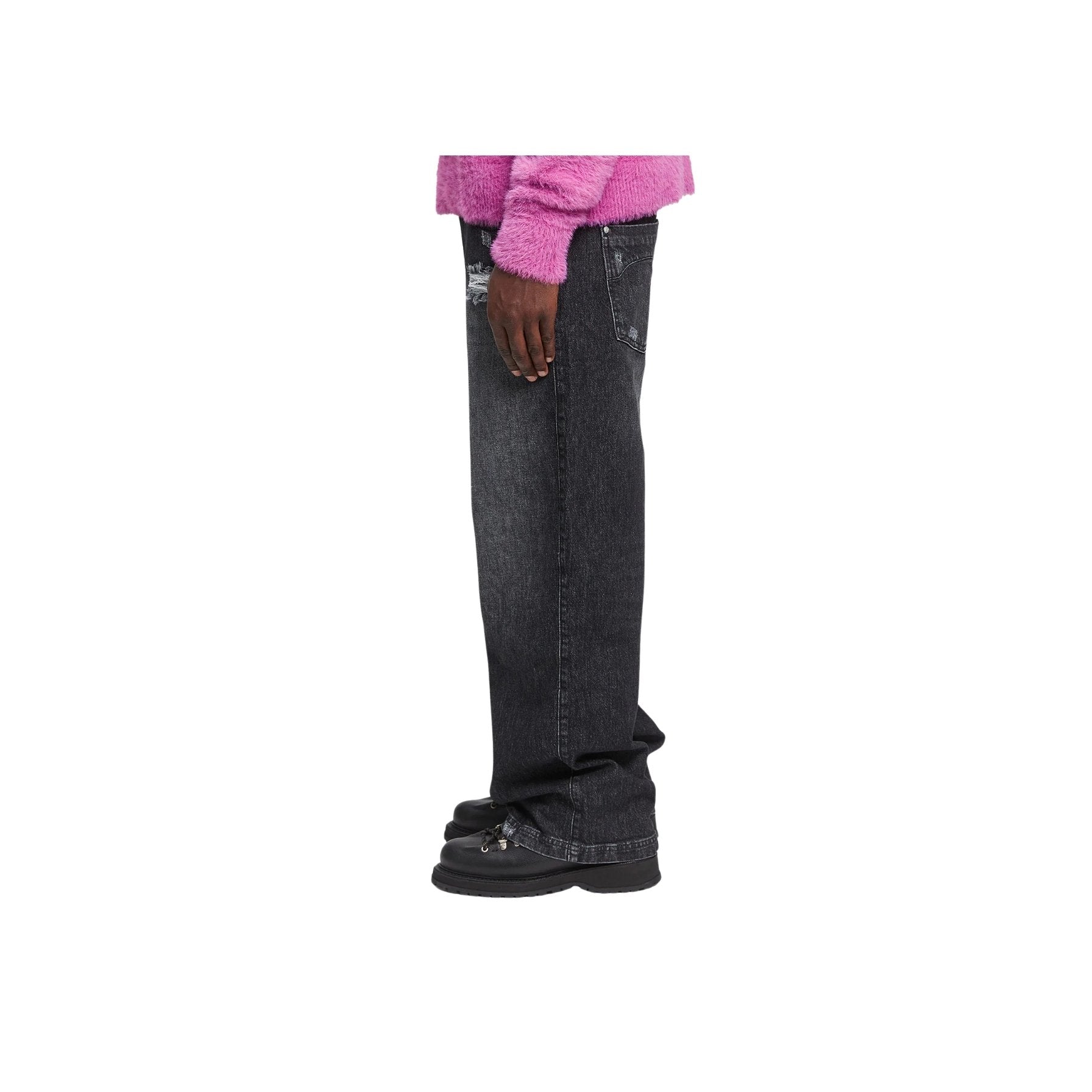 Person wearing black flared jeans and a pink sweater on a white background