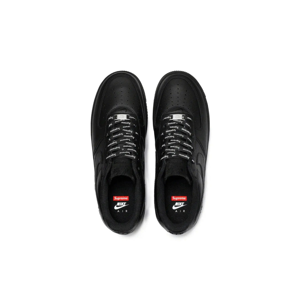 Black sneakers with Supreme and Nike logos on a white background
