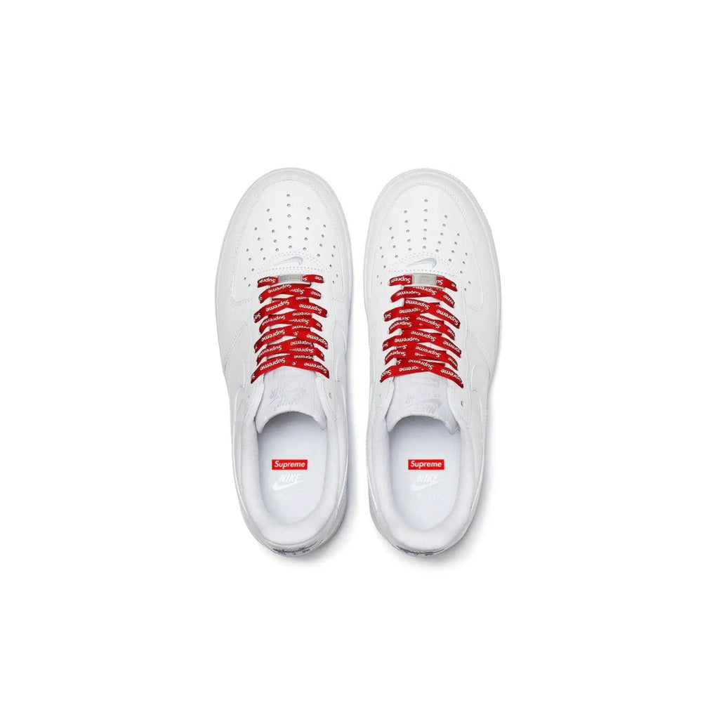 White sneakers with red laces on a white background