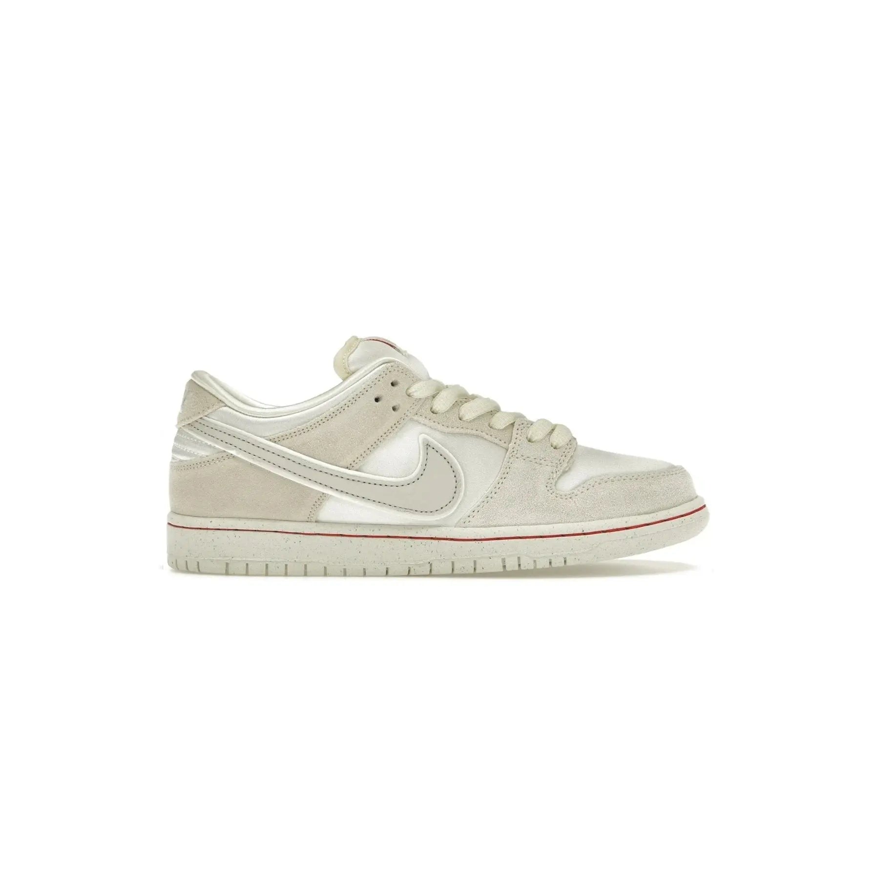 White sneaker with a red accent on a white background