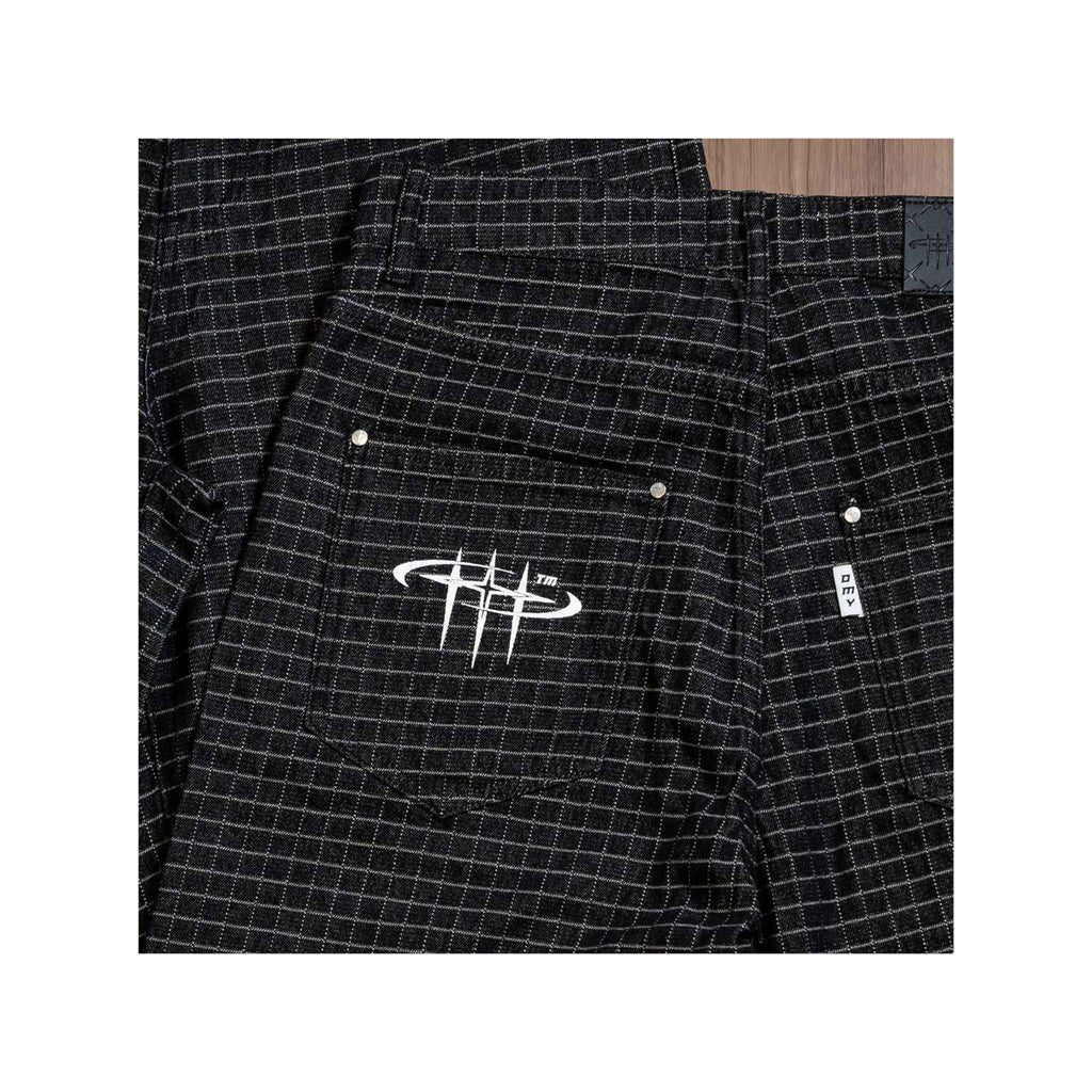 Black checkered pants with a logo on the pocket against a white background
