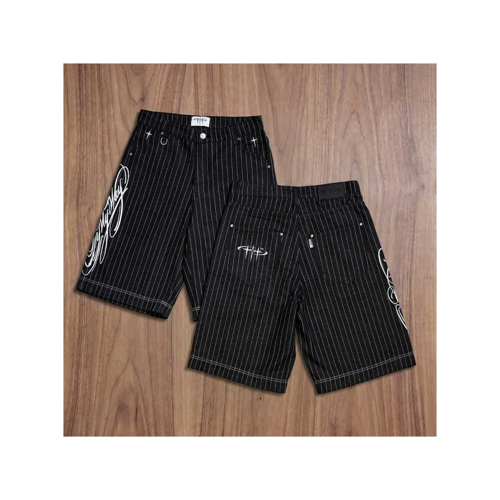 Black pinstripe shorts with white designs on a wooden surface