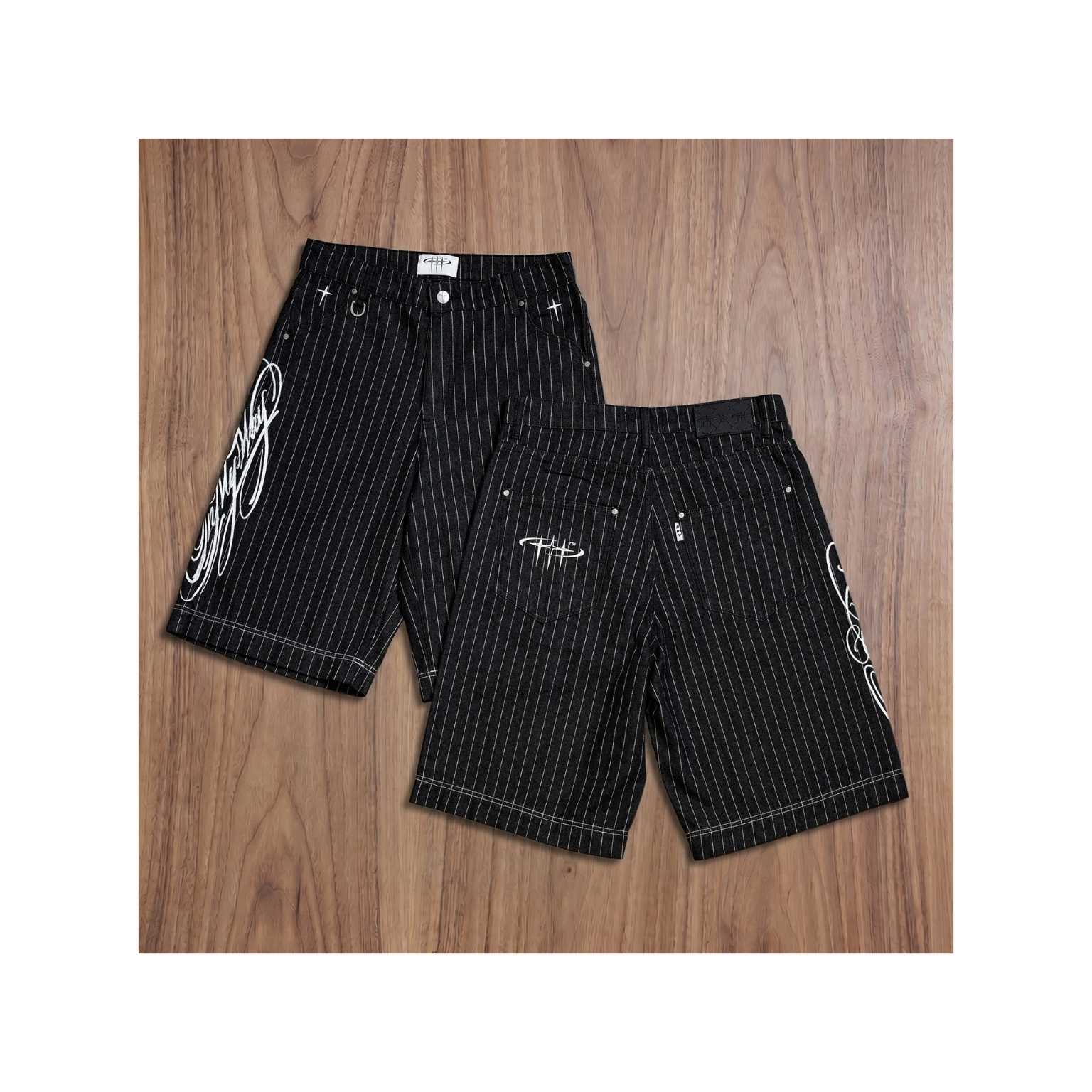 Black pinstripe shorts with white designs on a wooden surface