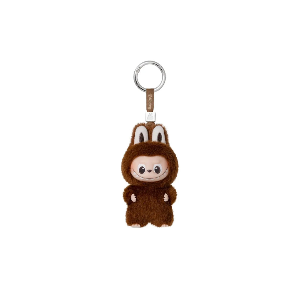 A brown plush monkey keychain charm wearing a furry hood, attached to a silver metal key ring with a small tan strap, shown on a plain white background.