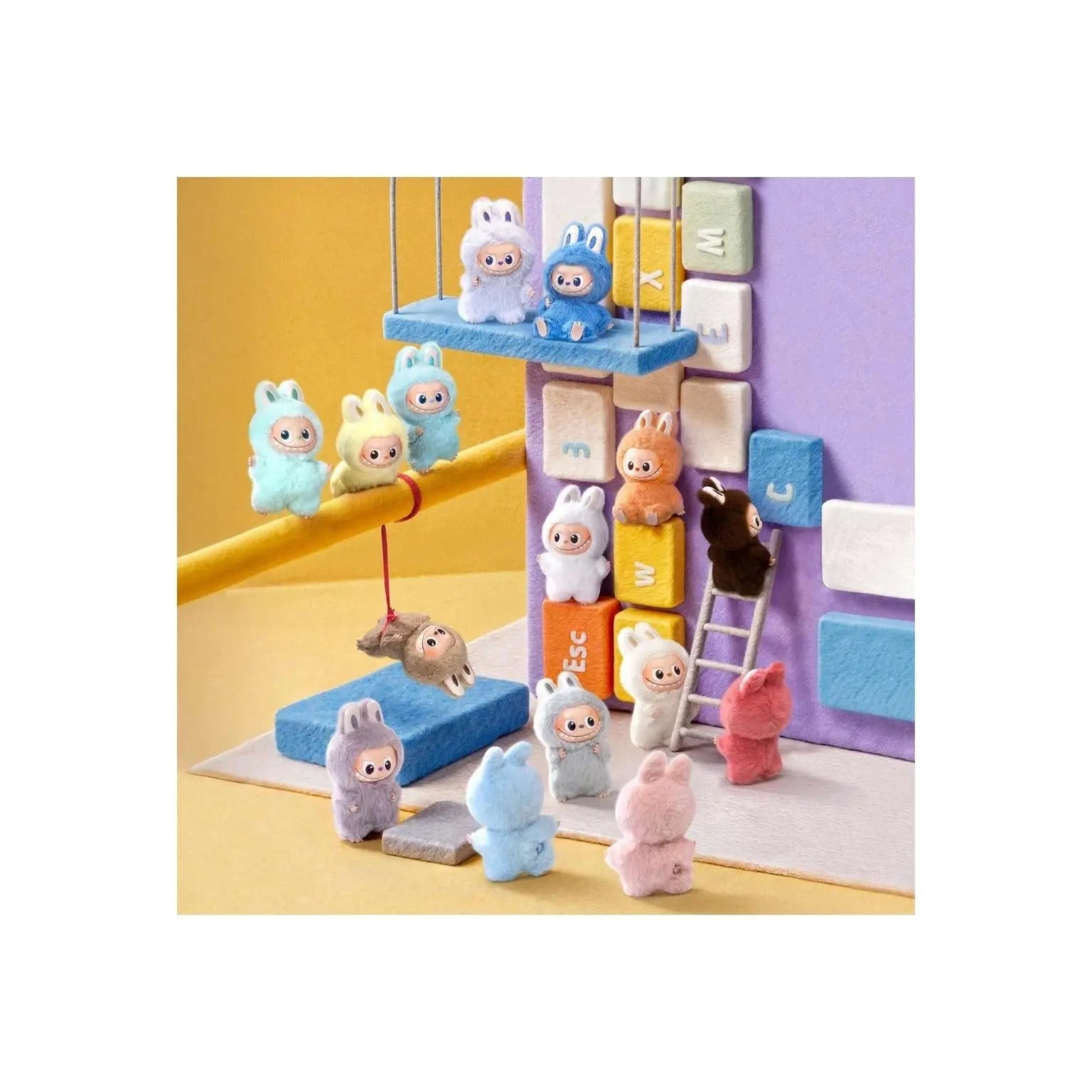 A colorful miniature toy set featuring small plush bunny figures and a matching block-and-rail play scene on a yellow studio background.