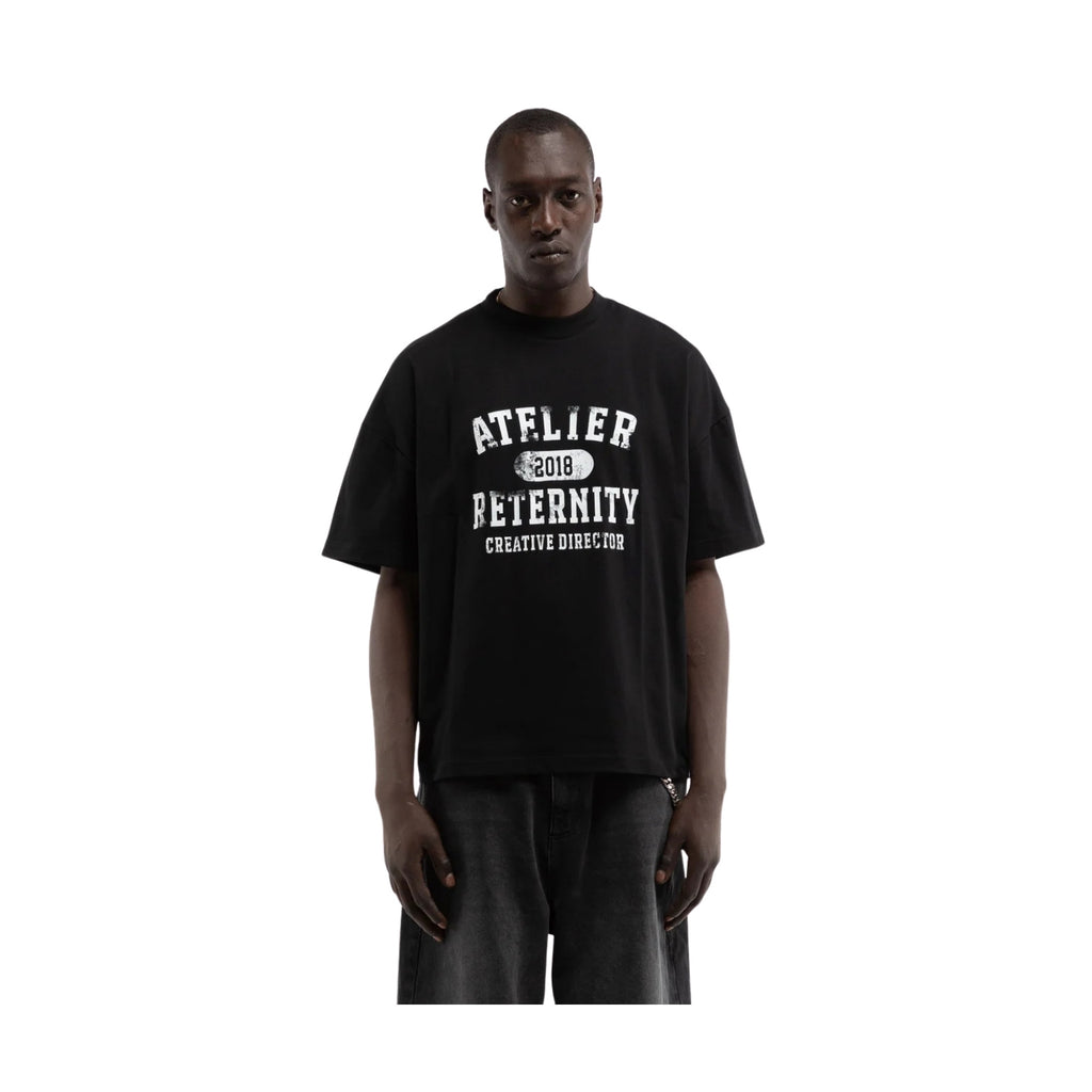 Person wearing a black t-shirt with white text on a white background
