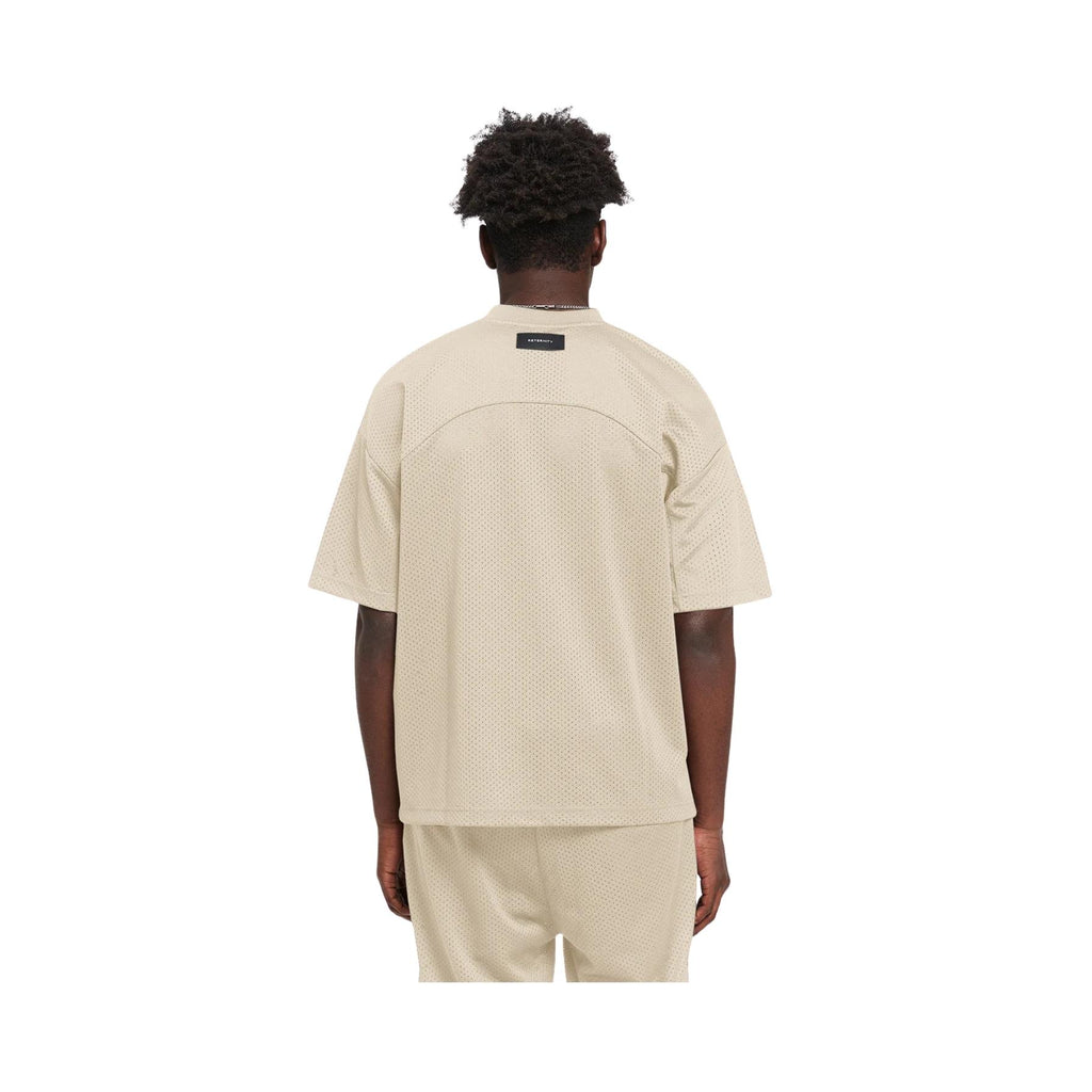 Person wearing a beige t-shirt and shorts set on a white background