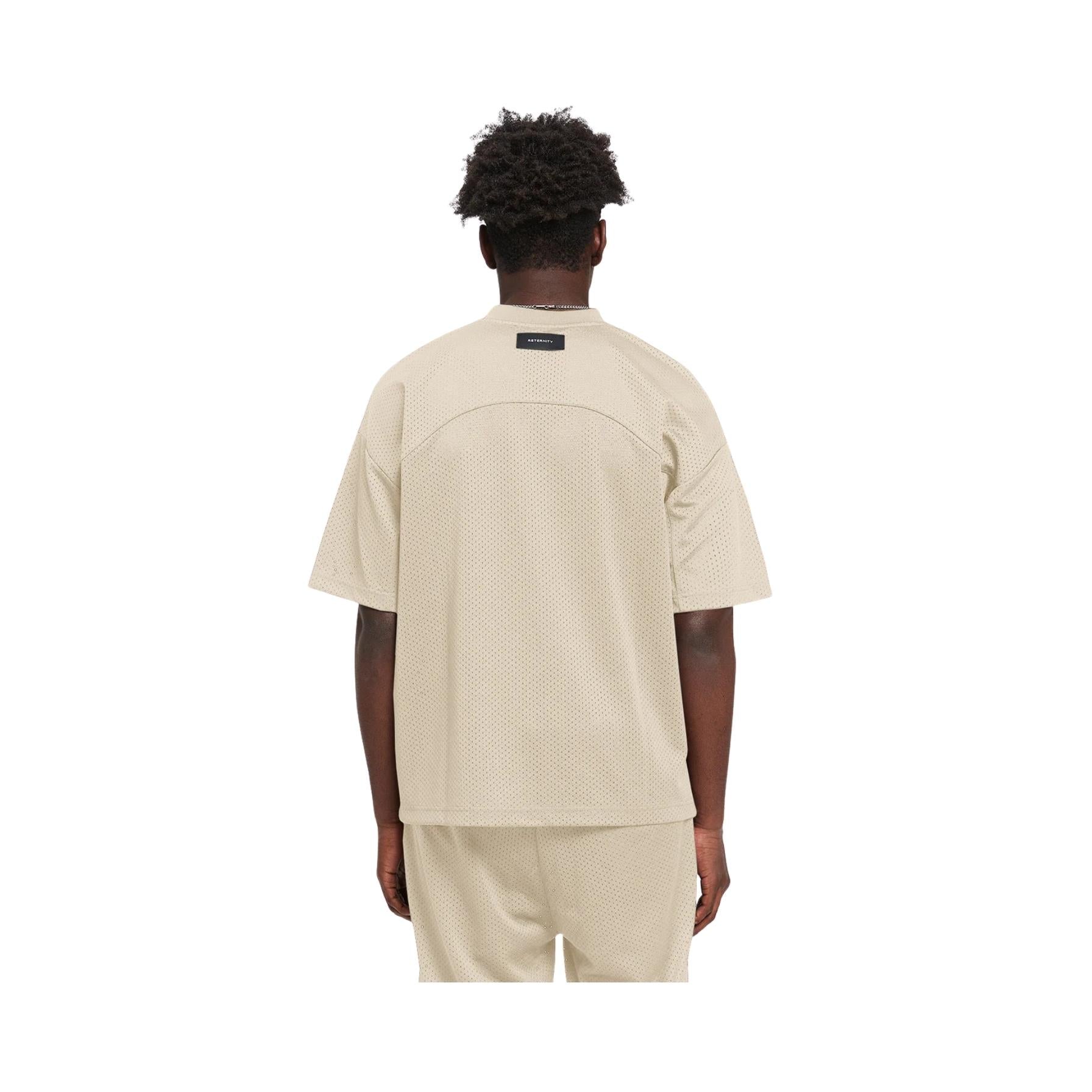 Person wearing a beige t-shirt and shorts set on a white background