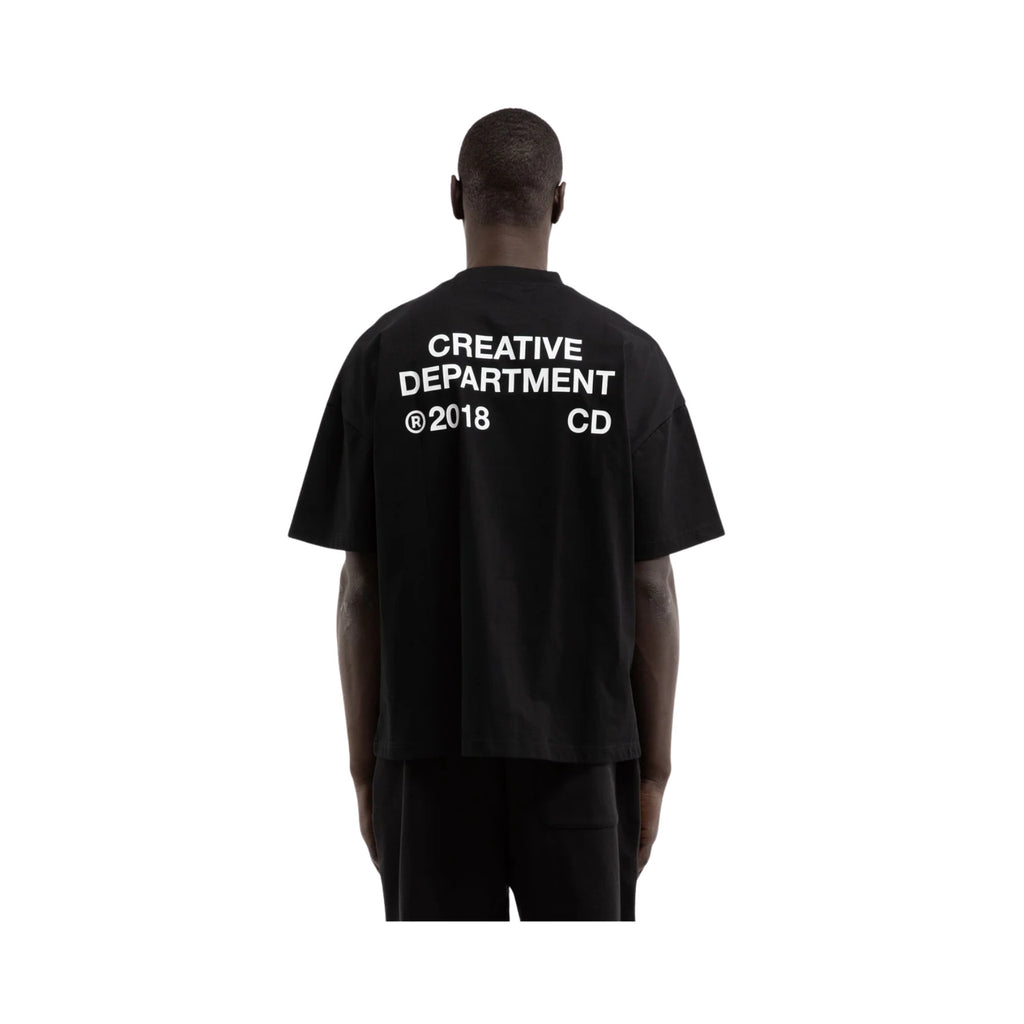 Person wearing a black t-shirt with 'Creative Department' text on the back, on a white background