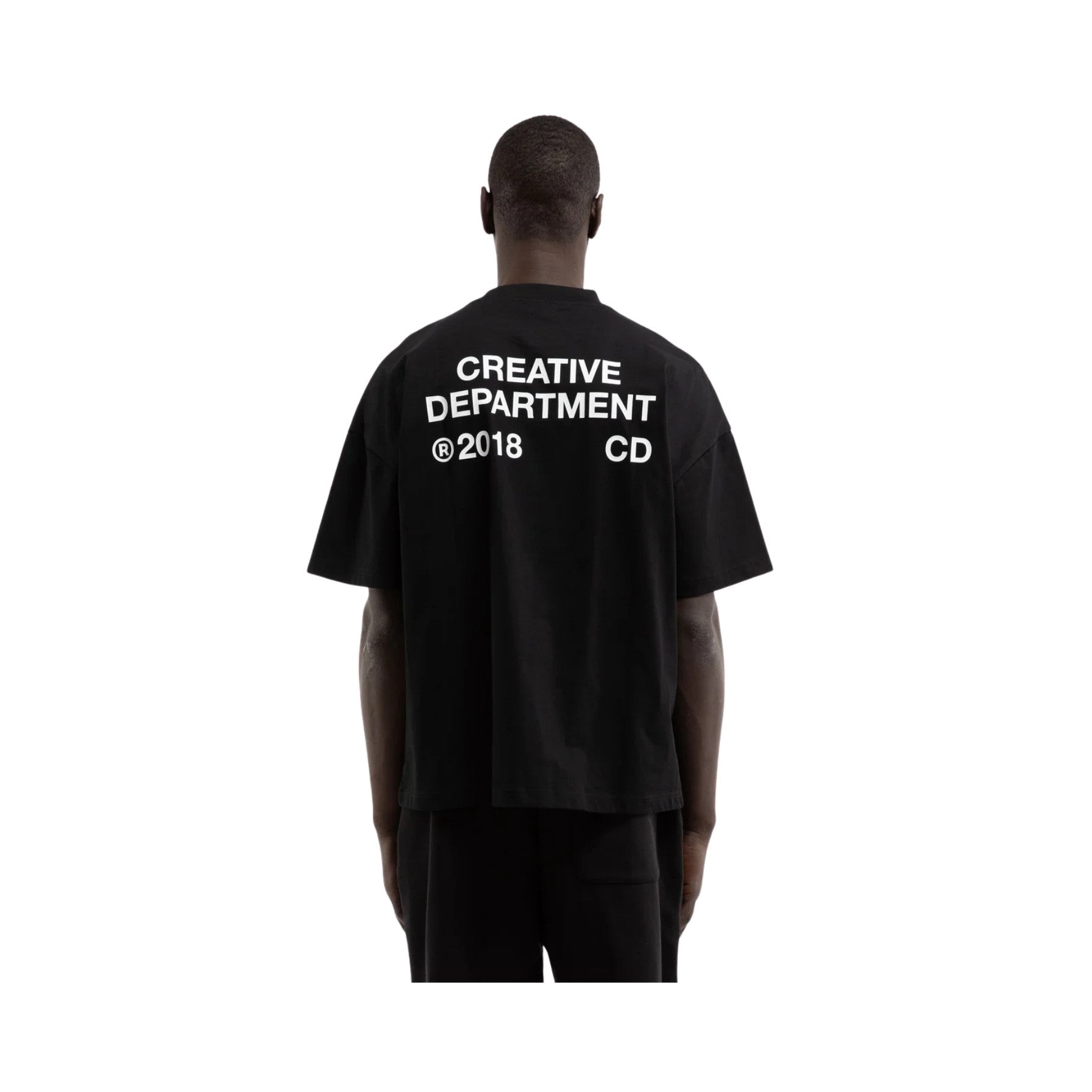 Person wearing a black t-shirt with 'Creative Department' text on the back, on a white background