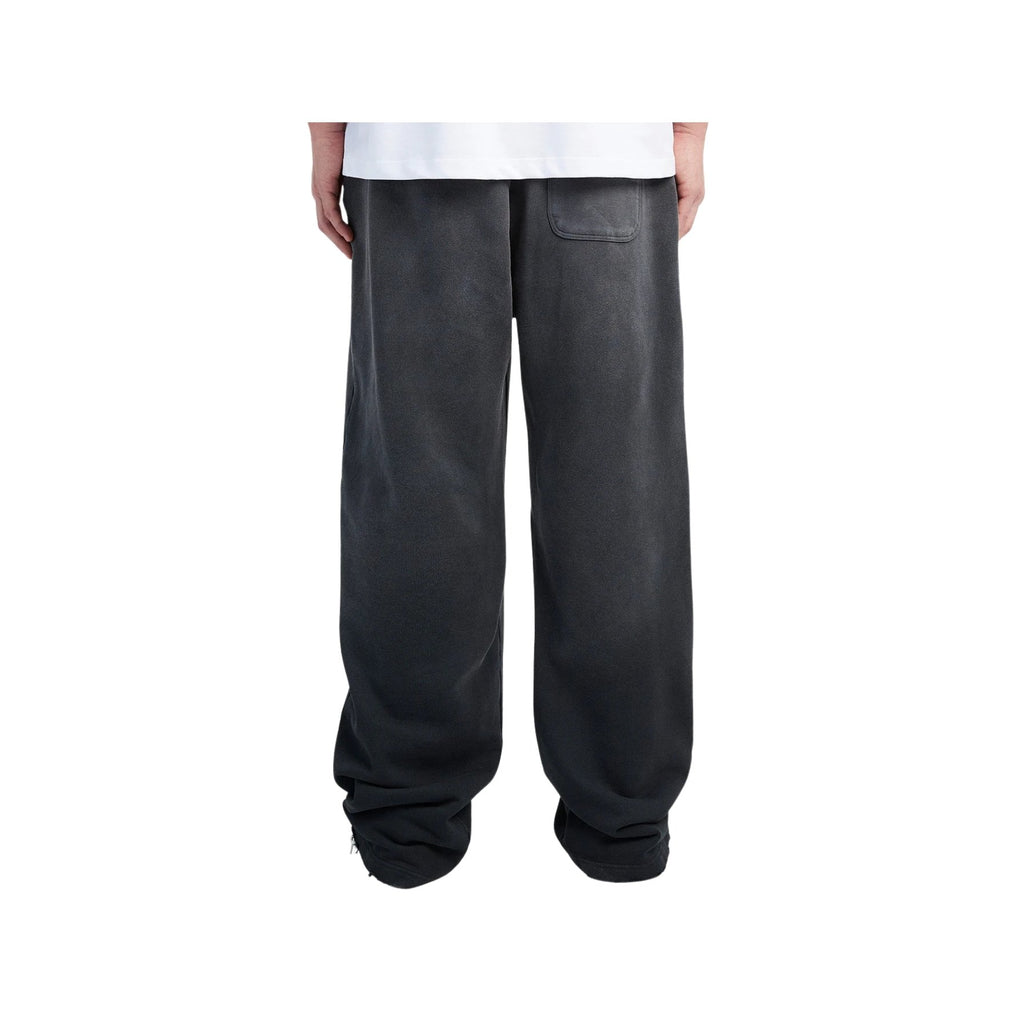 Person wearing dark gray sweatpants on a white background