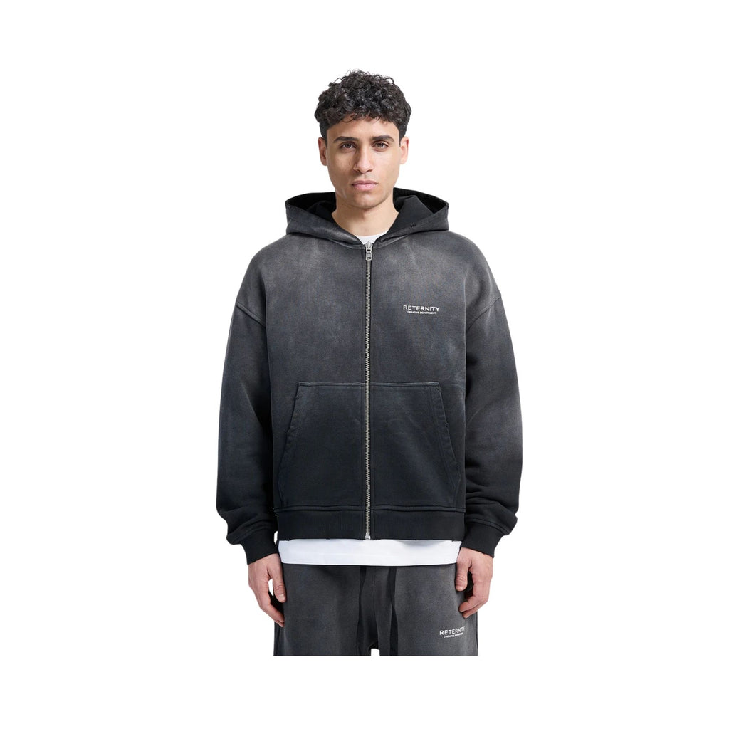 Person wearing a black hoodie with a brand logo on a white background