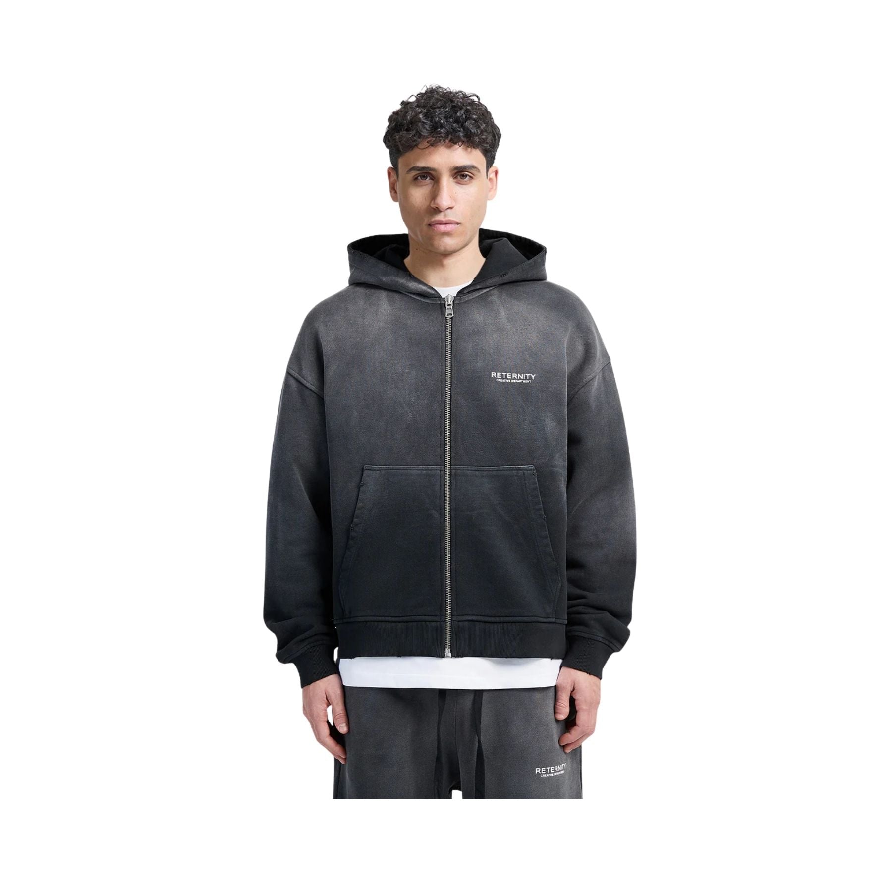 Person wearing a black hoodie with a brand logo on a white background