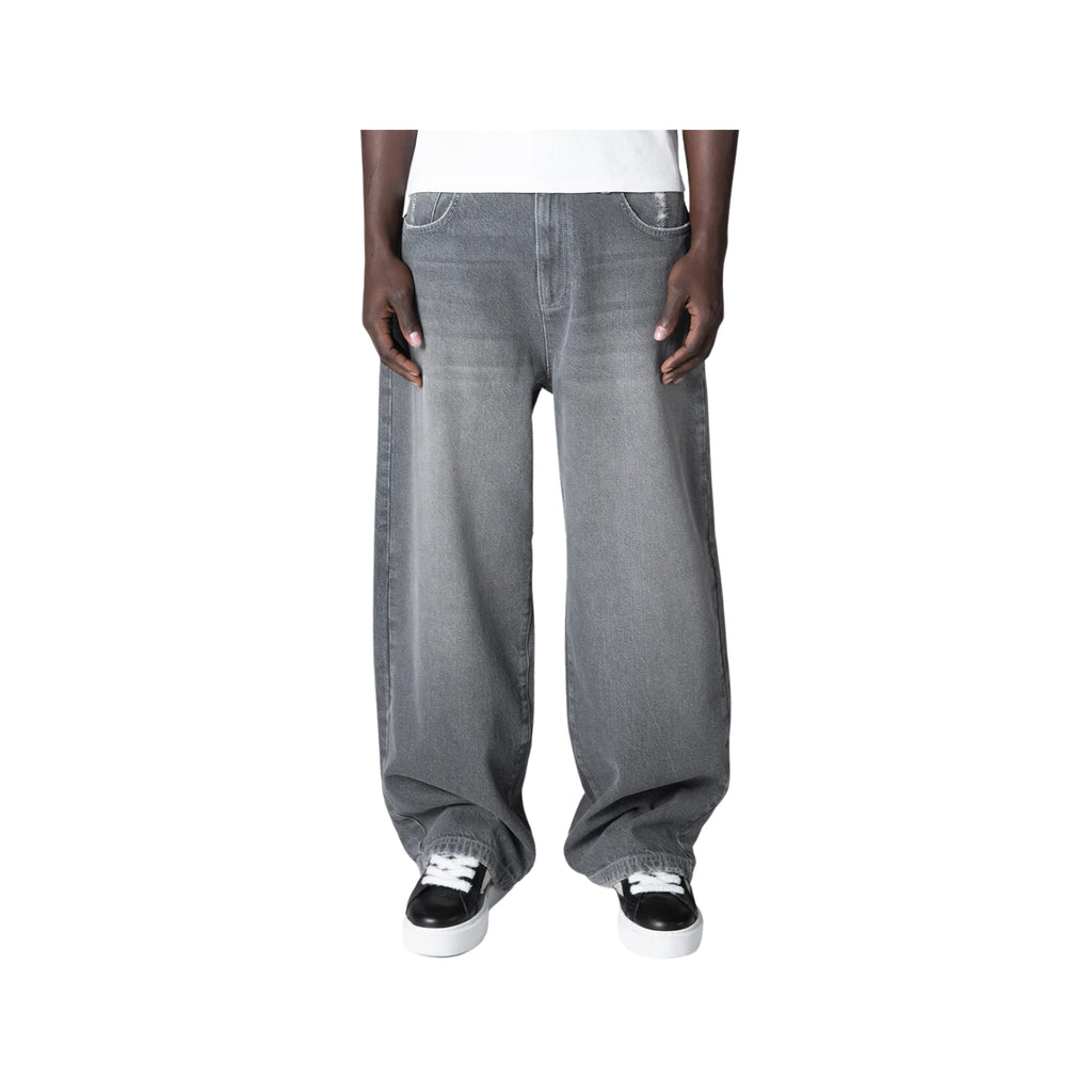 Gray baggy jeans worn by a person on a white background