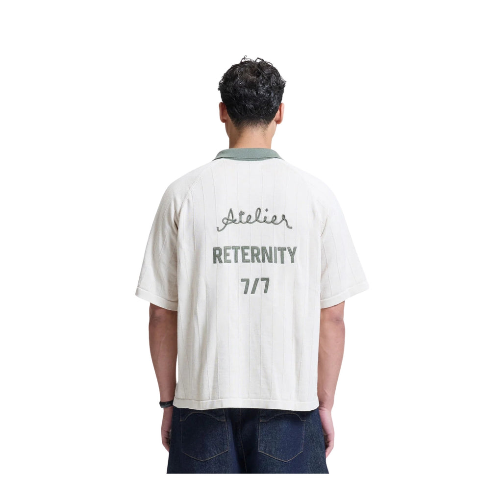 Person wearing a white t-shirt with text on the back, standing against a white background