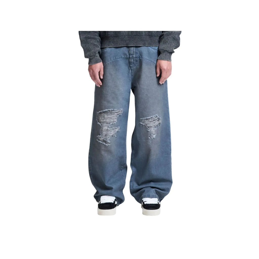 Person wearing distressed blue jeans on a white background