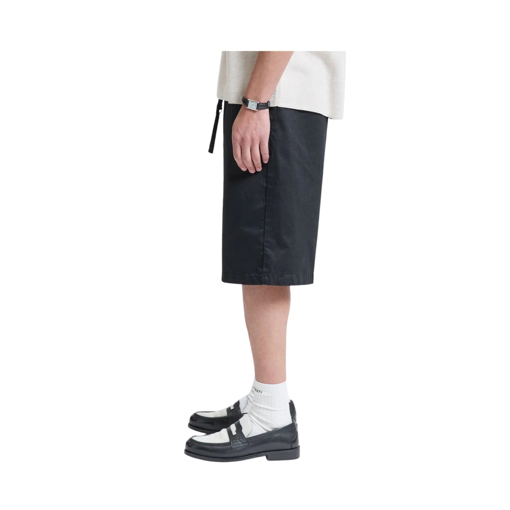 Person wearing black shorts on a white background