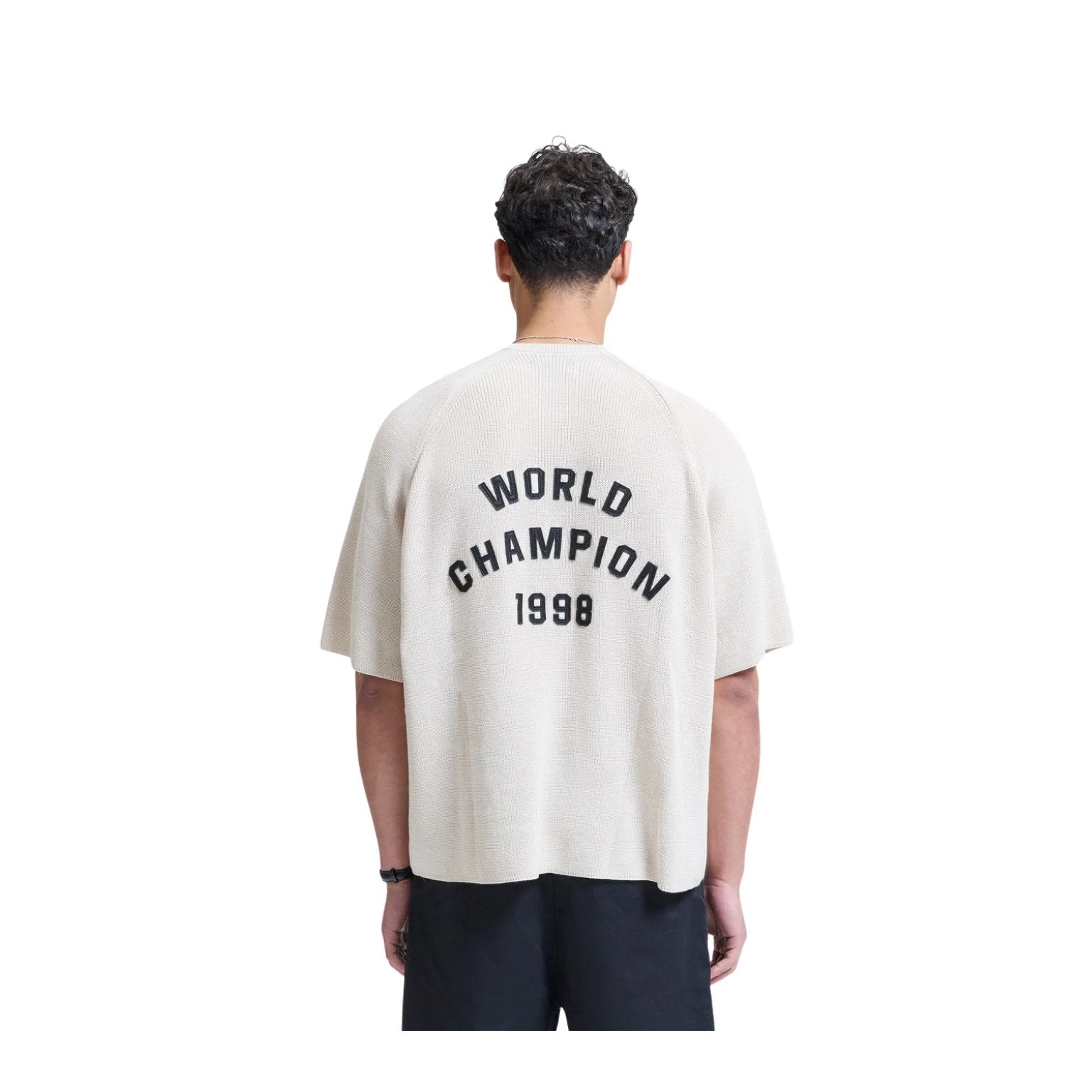 Person wearing a white t-shirt with 'World Champion 1998' text on the back, standing against a white background.