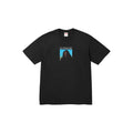 A black Supreme short-sleeve crewneck t-shirt featuring a graphic print of a figure against a blue sky with the word 'SUPREME' printed above, displayed flat on a white background.