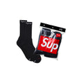 Black socks with 'Supreme' branding next to a packaging bag with 'Supreme' logo on a white background